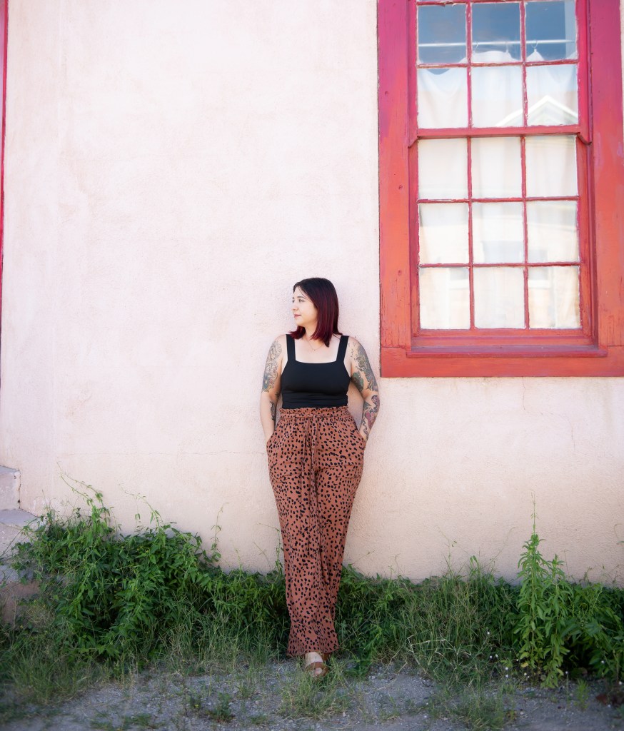 Sam leaning against a wall